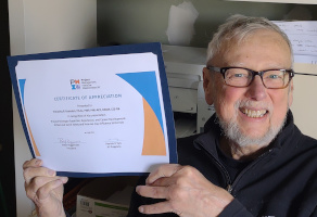 Selfie of Dr. Tim Brandon holding his PMIW Certificate of Appreciation
